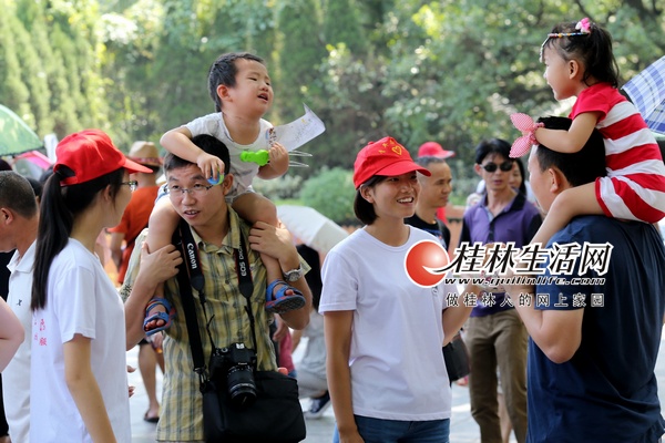桂林旅游学院的大学生志愿者以文明好客的举止，在象山景区门口为游客提供问询服务及旅游指导建议。